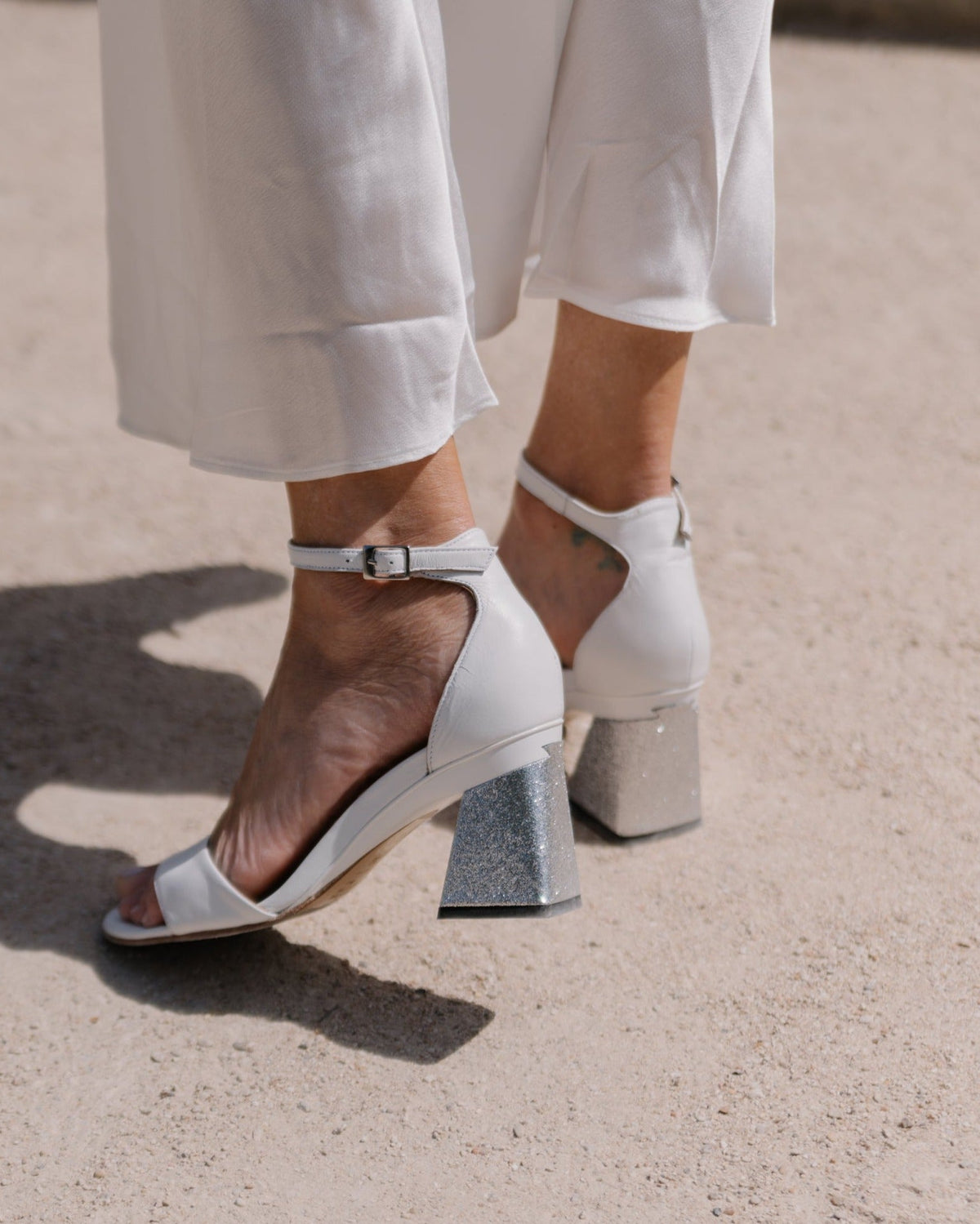 sandale blanche à talon portée avec pantalon blanc