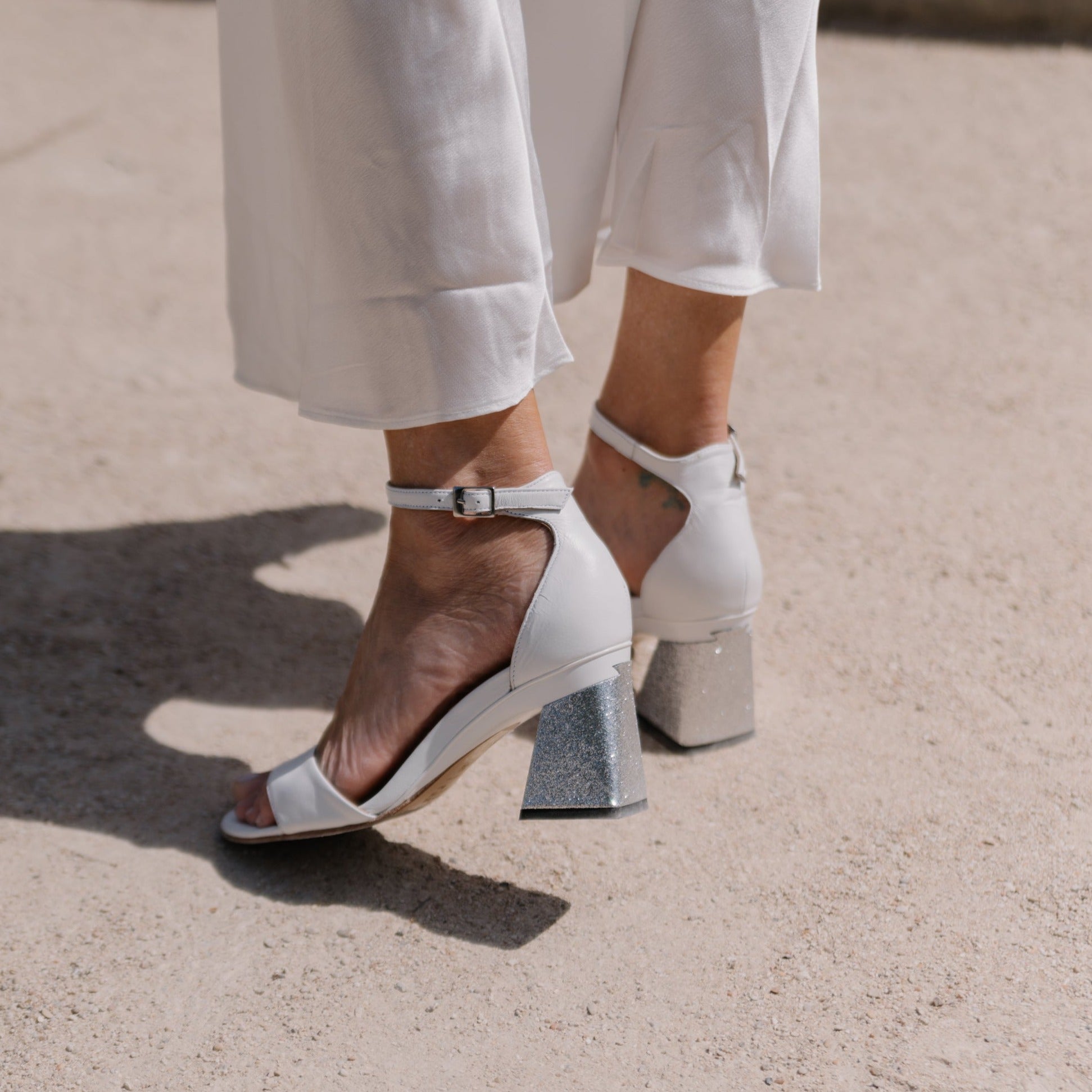sandale blanche à talon portée avec pantalon blanc
